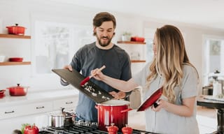 Couple cooking together in a modern kitchen with pots on the stove - Photo by Becca Tapert on Unsplash
