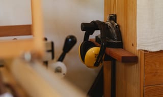 Woodworking workshop with ear protection and vise mounted on a wooden workbench. Photo from Pexels