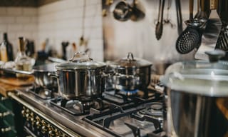 Pots on a lit gas range burner in a home kitchen