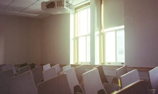 CO2 monitor mounted on a classroom wall showing air quality readings