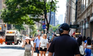 Commuter wearing over-ear headphones in a crowded city street