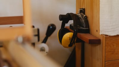 Woodworking workshop with ear protection and vise mounted on a wooden workbench. Photo from Pexels