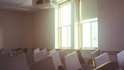 CO2 monitor mounted on a classroom wall showing air quality readings