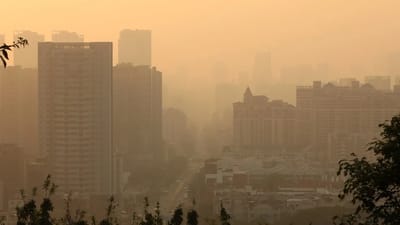 City skyline shrouded in hazy warm light, illustrating the air quality conditions measured by the AQI