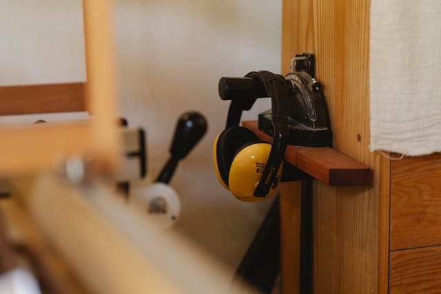 Woodworking workshop with ear protection and vise mounted on a wooden workbench. Photo from Pexels