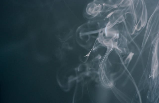 White smoke wisps rising against a dark background - Photo by Kseniya Budko on Pexels