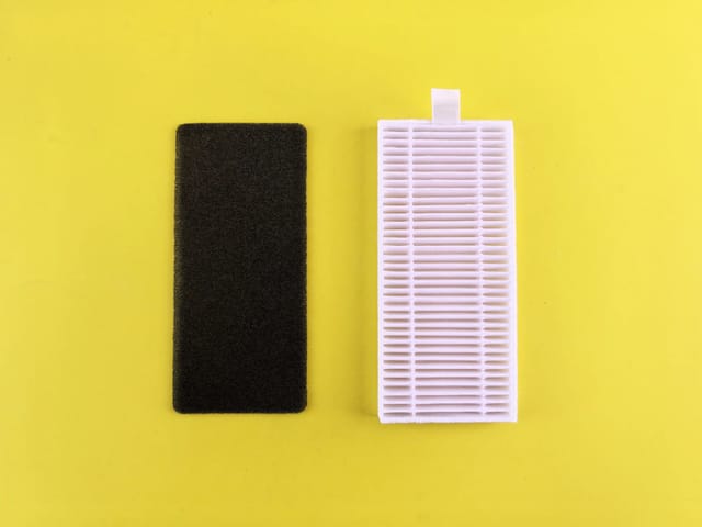 A dirty carbon pre-filter next to a clean white HEPA filter on a yellow background